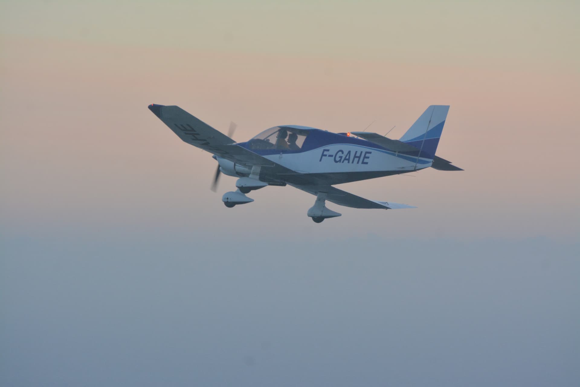 Avion léger privé F-GAHE en vol dans le ciel au coucher du soleil
